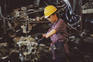 woman wearing a hard had working on an engine