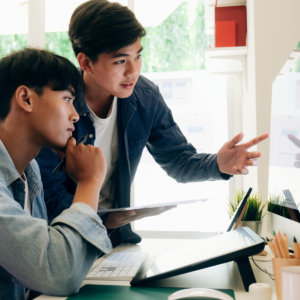 Two men looking at a screen and discussing
